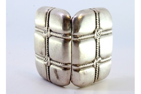  Caixa de comprimidos em prata em forma de mala com cordas em relevo e interior em dourado.